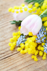Spring flowers: mimosa, tulips and muscari on wooden background
