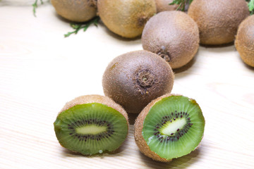 kiwis with branches on wooden background