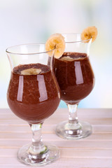 Cocktails with banana and chocolate on table on light