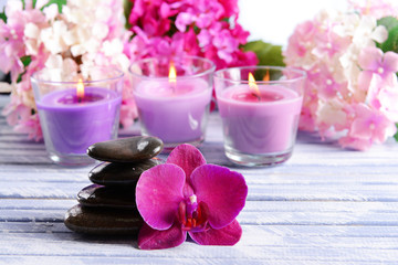Beautiful colorful candles, spa stones and flowers,on color