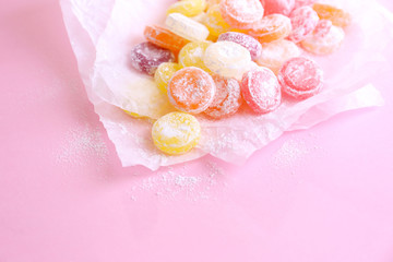 Sweet  multicolor candies on paper, on color background