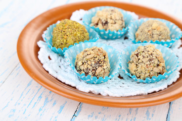 Set of chocolate candies, on plate, on wooden background