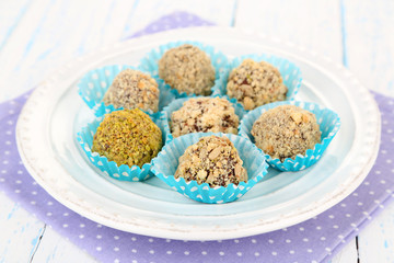 Set of chocolate candies, on plate, on wooden background