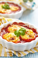 Baked halves eggs in tomato sauce