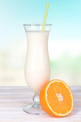 Milk shake on table on light blue background