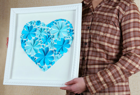 Woman holding beautiful handmade picture with heart from paper
