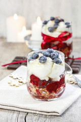 Layer strawberry, blueberry and muesli dessert in glass goblet