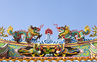 Chinese dragons fight at top of roof blue sky background