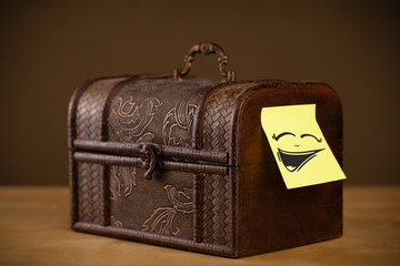 Post-it note with smiley face sticked on jewelry box