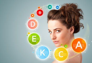 Pretty young girl with colorful vitamin icons and symbols