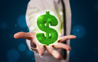 Young businessman presenting green glowing dollar sign