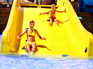Child on water slide at aquapark.