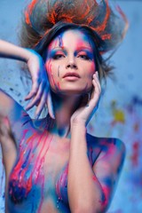 Young woman muse with creative body art and hairdo