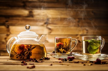 Théière et tasses en verre avec du thé sur fond de bois