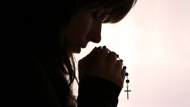 Silhouette of a woman hand praying, close up