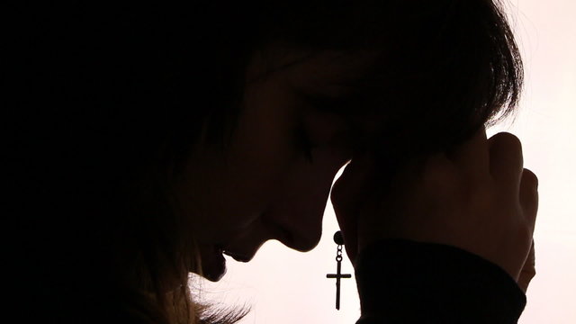 Silhouette of a woman hand praying, close up