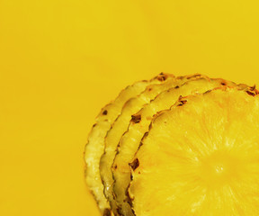 Pineapple pieces on yellow background