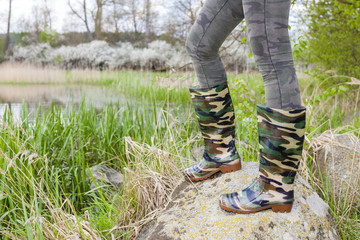 detail of woman wearing rubber boots in spring nature
