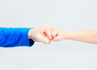 Fists of an adult and a child on white