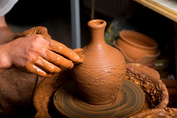 hands of a potter, creating an earthen jar
