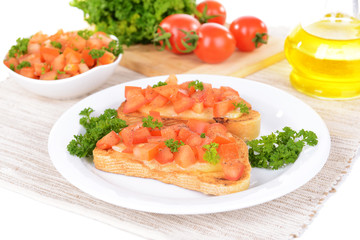 Delicious bruschetta with tomatoes on plate on table close-up