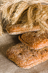 Rye bread and wheat on cloth sack, close-up