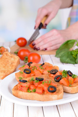 Delicious bruschetta with tomatoes on plate on table close-up