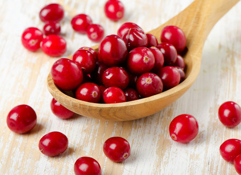 Cranberries in a  wooden spoon