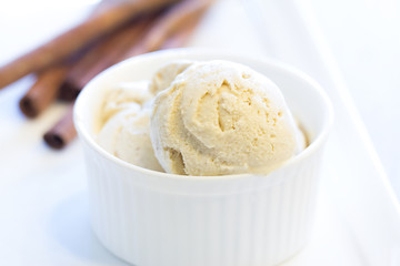 Fototapeta na wymiar Scoop of homemade cinnamon ice cream with cinnamon