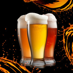 Different beer in glasses wish splash isolated on black backgrou