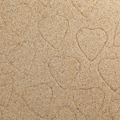 The symbol of heart is drawn on clean sand