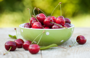 Fresh cherries in a bowl on garden table