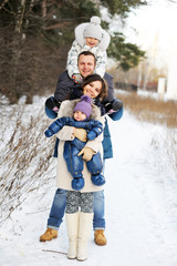 Fototapeta na wymiar Happy family enjoying a walk in winter park