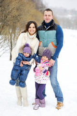 Happy family enjoying a walk in winter park