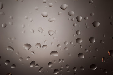 Water drops on glass with grey background as metal surface