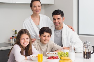 Obraz na płótnie Canvas Portrait of happy kids enjoying breakfast with parents