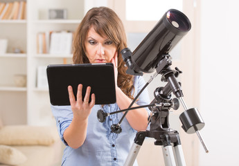Beautiful woman with telescope and tablet