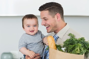 Fototapeta premium Happy baby being carried by businessman