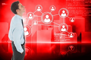 Composite image of happy businessman standing with hand in pocke