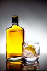 Glass and bottle of hard liquor like scotch, bourbon, whiskey or