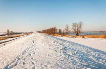 Fototapeta na wymiar Snowy Dutch dike with footprints