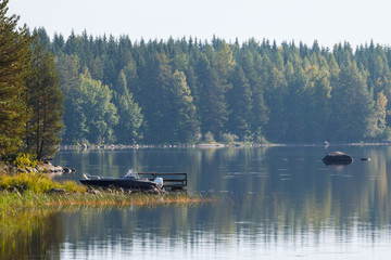landscape with motor boat on the coast of lake, Finland