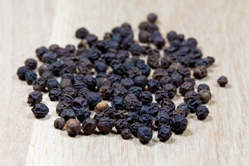 Black pepper on wooden surface
