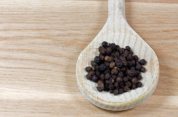 Black pepper on wooden spoon
