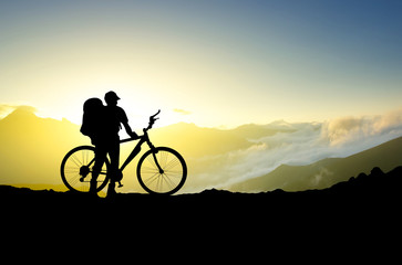 Fototapeta na wymiar Silhouette of a bike and tourist. Sport and active life concept