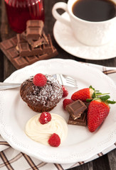 Fototapeta na wymiar Chocolate muffin served with cream and fresh berris