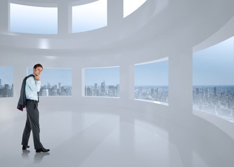 Obraz premium Composite image of serious businessman holding his jacket