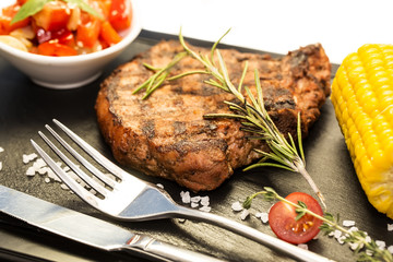 Grilled steak with sauce and greens