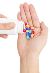 Closeup of medicine capsules being poured from pill bottle into
