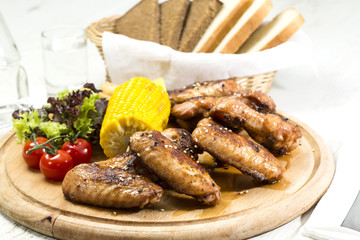 chicken wings are grilled on a wooden platter